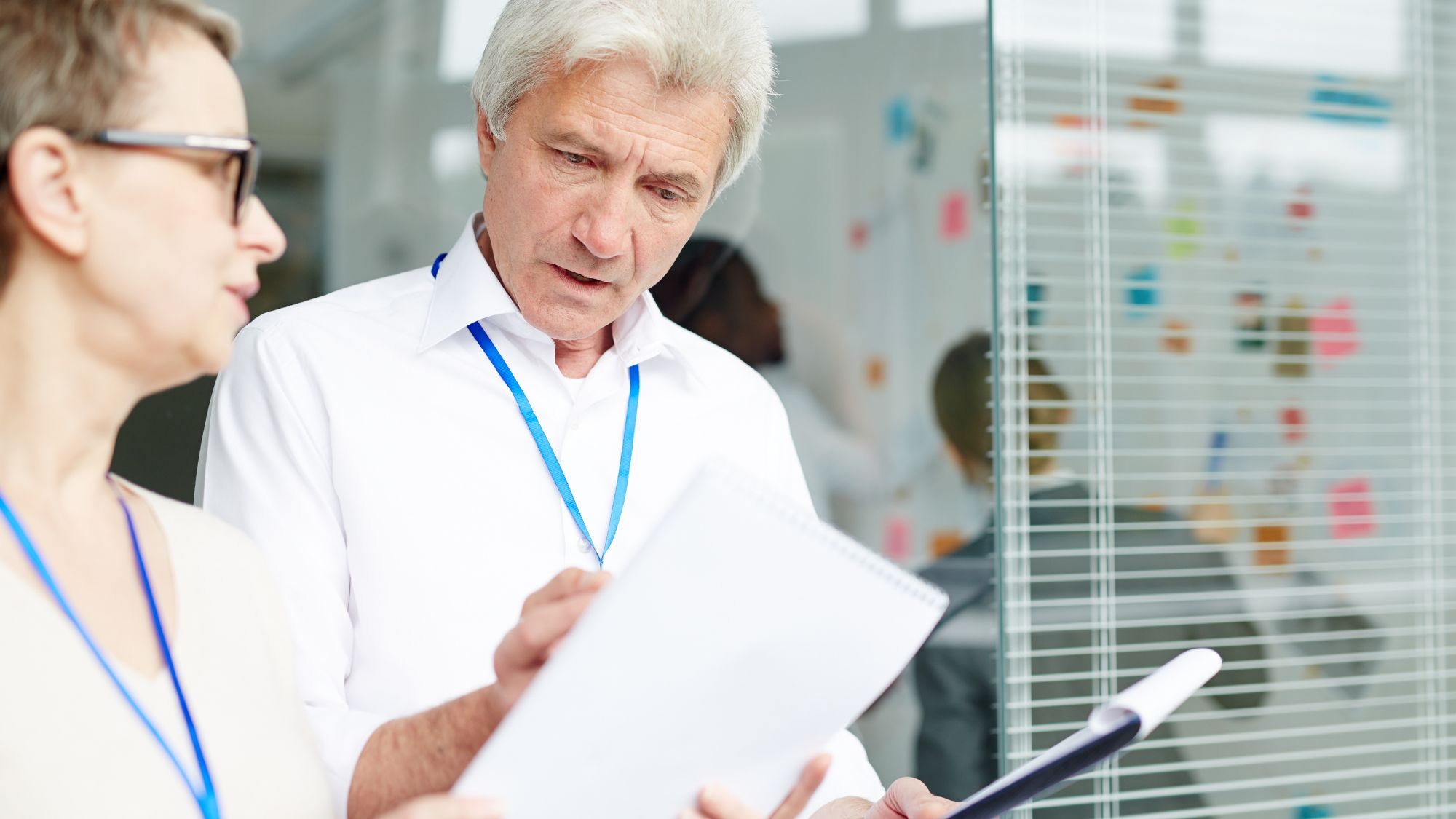 A man and woman intently reviewing documents for a security needs assessment near me.