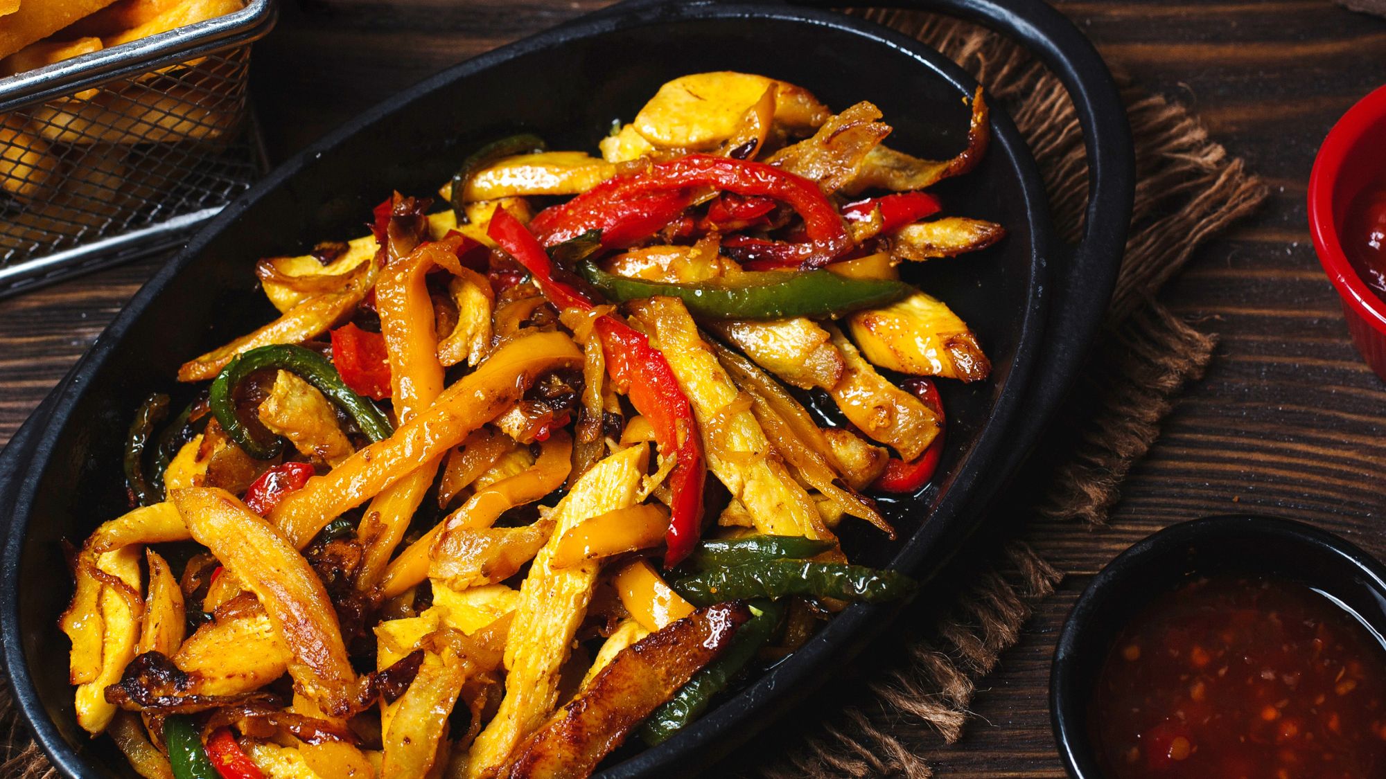 Savory black dish with chicken and peppers, served at loaded fries takeaway or cook loaded fries at home